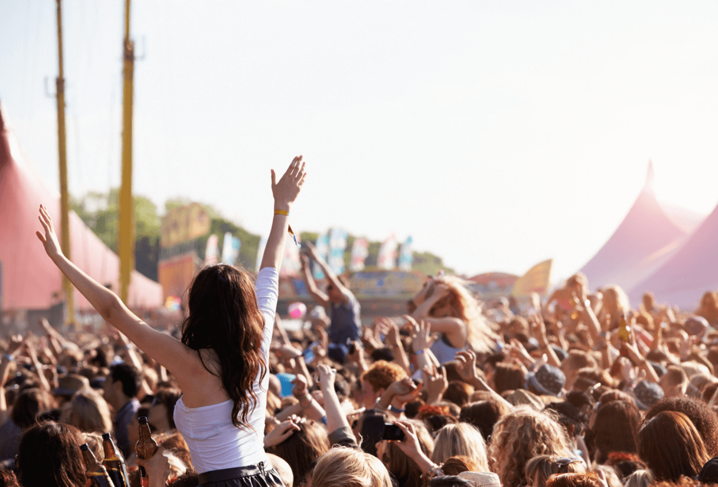 Crowds Enjoying Themselves At Outdoor Music Festival With Arms in The Air