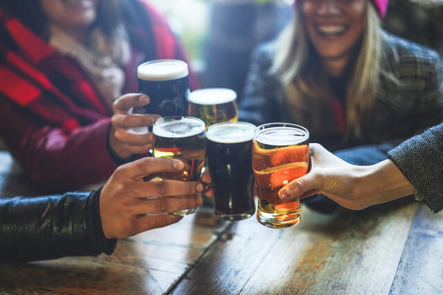 Group of friends toasting pints of beers.