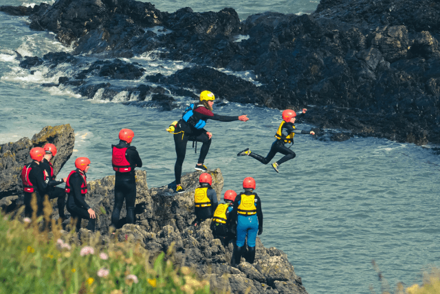 A child jumping into the sea during a coasteering experience