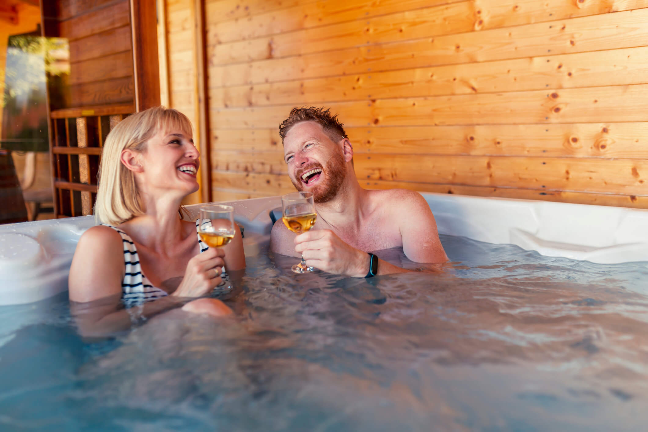 Couple relaxing and drinking wine in a hot tub