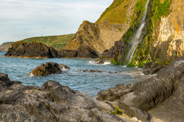 A View Of Tresaith Waterfall From The Rocks On The Beach